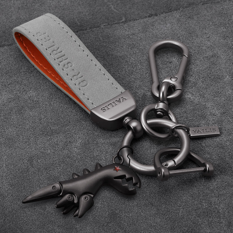 Porte-clés dinosaure en métal avec cordon en daim