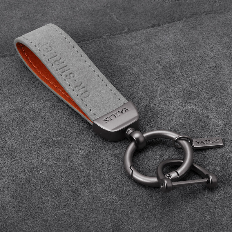 Porte-clés dinosaure en métal avec cordon en daim