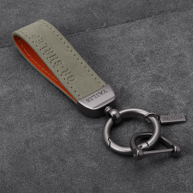 Porte-clés dinosaure en métal avec cordon en daim