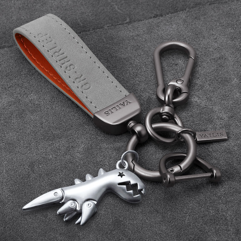 Porte-clés dinosaure en métal avec cordon en daim